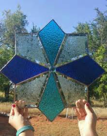 A Person Holding Up A Stained Glass Sun Catcher