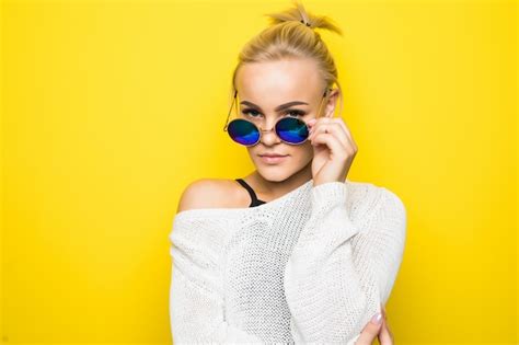Jeune Fille Blonde Souriante En Pull Blanc Moderne En Lunettes De Soleil Bleu Brillant Pose Sur