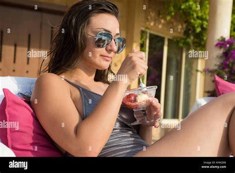 Beautiful Woman Wearing Bikini And Sunglasses Eating Ice Cream While