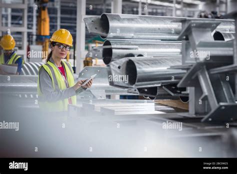 Portrait Confident Female Worker With Digital Tablet In Steel Factory