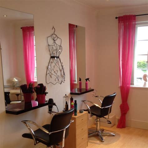 A Hair Salon With Pink Curtains And Mannequins