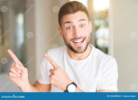 Young Handsome Man Wearing Casual White T Shirt At Home Smiling And Looking At The Camera