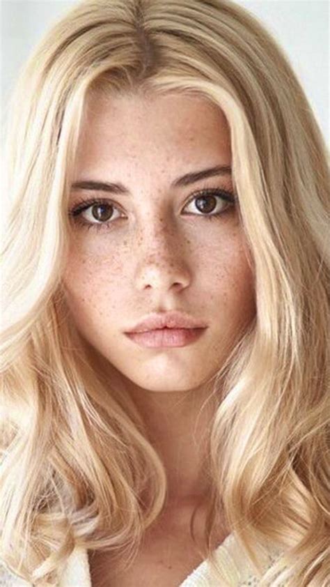 A Woman With Long Blonde Hair And Freckles