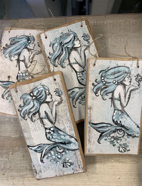 Four Wooden Plaques With Mermaids Painted On Them