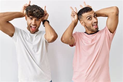 Joven Pareja Gay Parado En Un Contexto Aislado Posando Divertido Y Loco Con Los Dedos En La