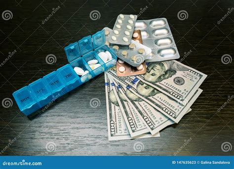 Pillbox Pills And Tablets On Dollar Money On Dark Wooden Table