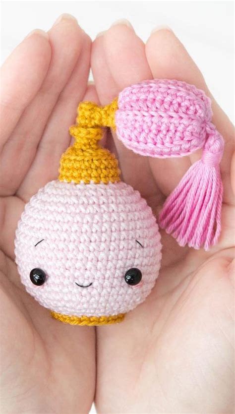 A Hand Holding A Small Crocheted Toy With A Tassel On It S Head