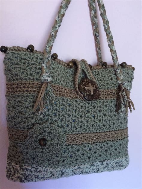 A Crocheted Bag Hanging On The Wall With Buttons And Handles Made To