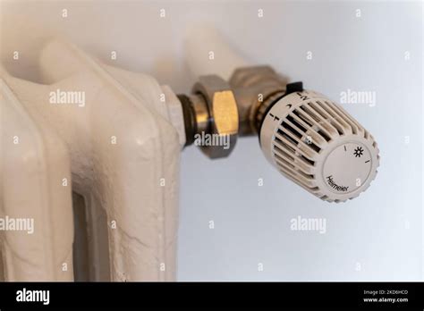 A thermostat of central heating with a cutout of cast iron radiator Stock Photo - Alamy