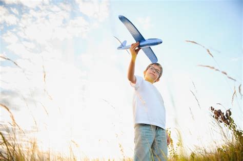 El niño corre con un avión de juguete hijo sueña con volar niño feliz