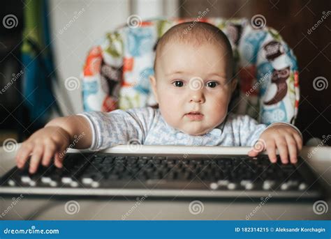 Portrait Of A Cute Baby Boy Sitting And Playing With A Keyboard Stock