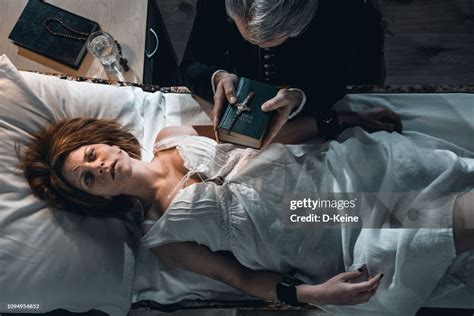 Old Priest Performing Exorcism Ritual Of Young Possesed Woman High Res