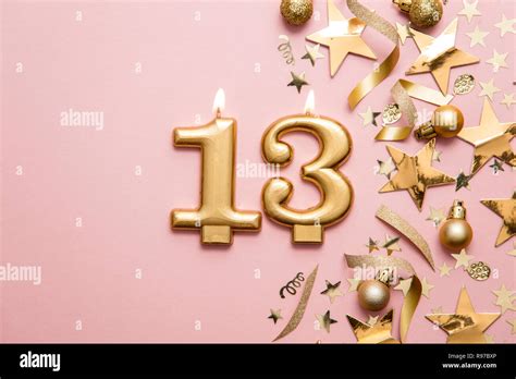Number 13 Gold Celebration Candle On Star And Glitter Background Stock