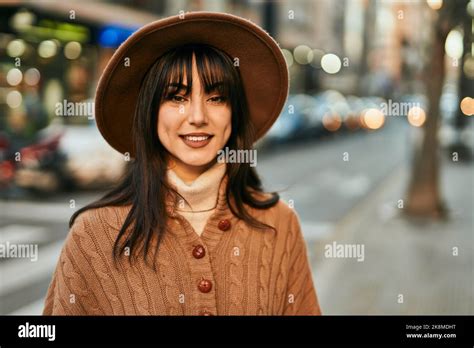 Brunette Woman Wearing Winter Hat Smiling Outdoors At The City Stock