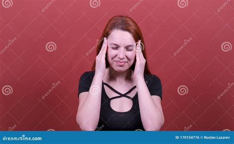 Redhead Woman Looks At Camera Rubs Temples With Hands Headache