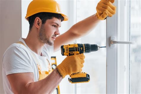 Handyman Em Uniforme Amarelo Instala Nova Janela Usando Chave De Fenda