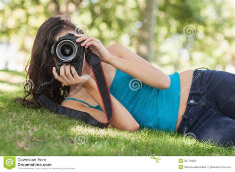 Front View Of Pretty Brunette Woman Lying On A Lawn Taking A Picture Stock Image Image Of