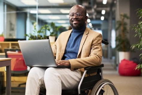 Happy Young Black Man With Disability Sitting In Wheelchair In Office