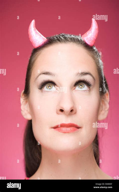 Portrait Of Woman Wearing Devil Horns Looking Up Stock Photo Alamy