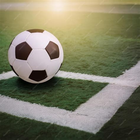 Una pelota de fútbol está en el suelo al sol | Vector Premium generado