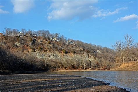 There Is A Large Body Of Water In Front Of A Hill With Houses On It