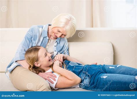 Grandmother And Granddaughter Having Fun Together On Sofa Stock Image