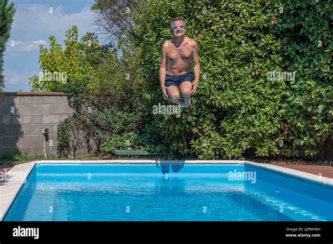 Middle Aged White Man With Funny Goggles Dives Into The Pool