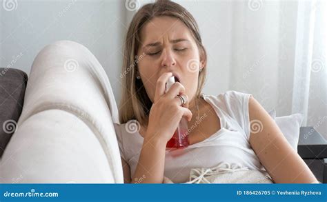 Sick Young Woman With Sore Throat Using Throat Spray Stock Image