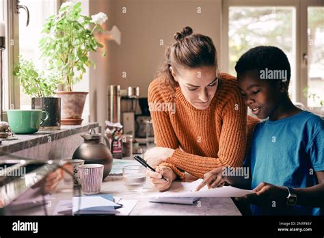 Mother Assisting Son While Doing Homework At Home Stock Photo Alamy