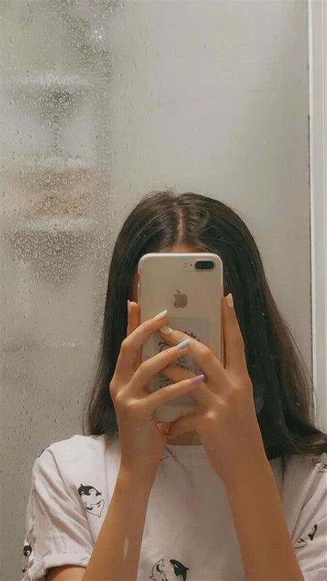 A Woman Taking A Selfie In Front Of A Window With Rain Drops On The Glass