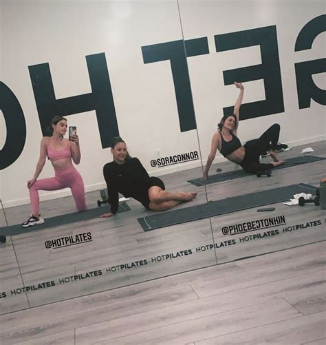 A Group Of People Doing Yoga Poses In Front Of A Large Sign With The