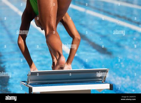 Swimmer In Low Position On Starting Block In A Swimming Pool Stock