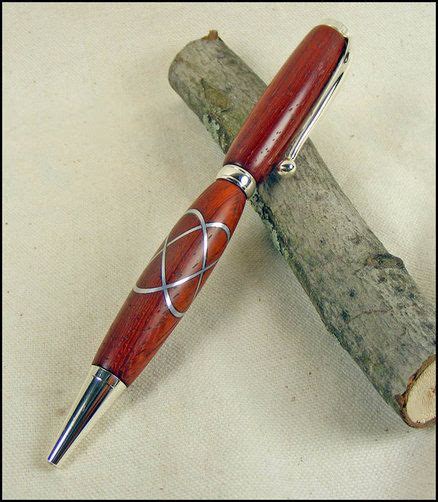 A Wooden Pen Sitting On Top Of A Piece Of Wood