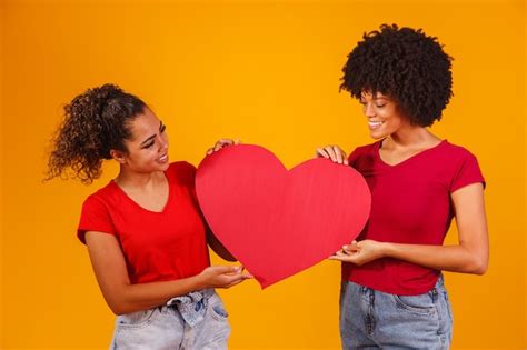 Premium Photo Valentine Lesbian Couple Holding A Paper Heart Valentine S Day Concept