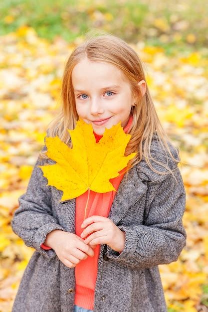 Premium Photo Happy Young Girl Playing With Falling Yellow Leaves In