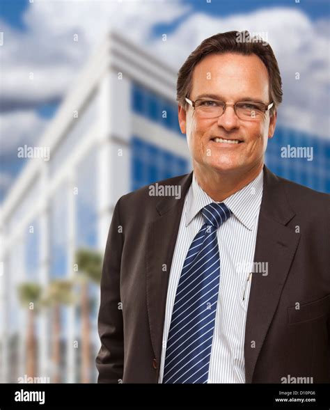 Handsome Businessman In Suit And Tie Smiling Outside Of Corporate