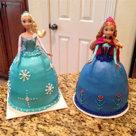 Two Frozen Princess Cakes Sitting On Top Of A Counter