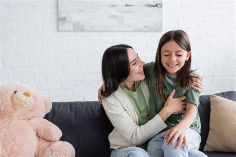 Excited Brunette Babysitter Hugging Cheerful Girl Stock Photo Image Of Closeness Professional