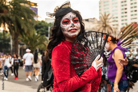 Mujer Joven Caracterizada Como Catrina Con Abanico Negro Y Vestido Rojo