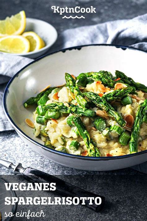 A Bowl Filled With Pasta And Asparagus On Top Of A Table Next To Lemon