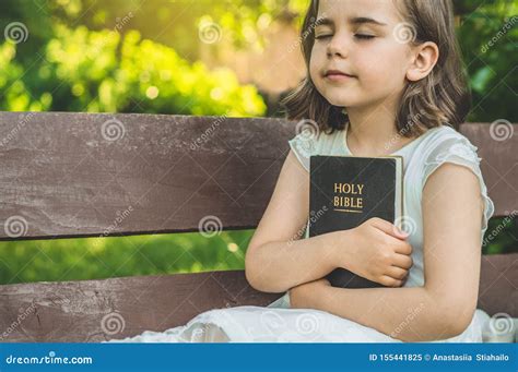 Reading The Holy Bible In Outdoors Christian Girl Holds Bible In Her