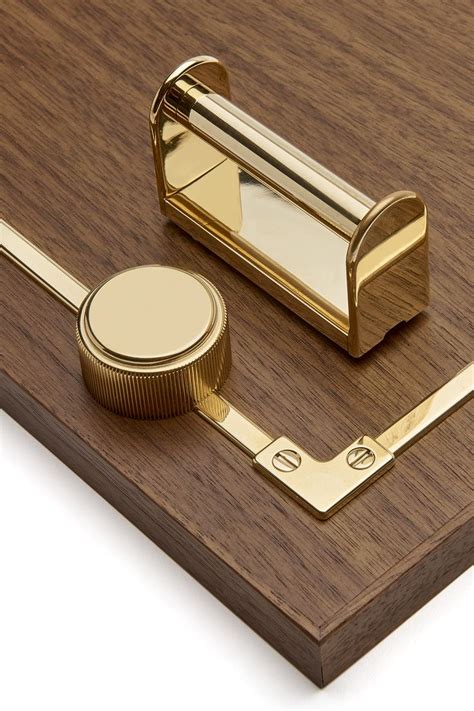 A Close Up Of A Wooden Surface With Brass Hardware On It And An Object