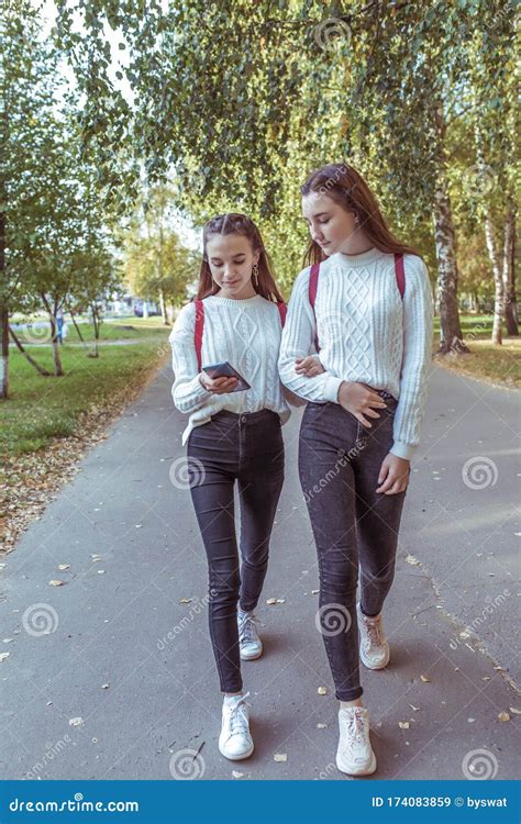 Two Girls Schoolgirls Walk By Hand Returning Home After School