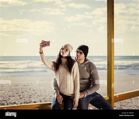 Very Happy Couple In Love Taking Selfie On The Beach In Autmun Day