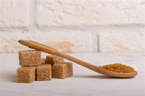 Premium Photo Cubes Of Cane Sugar And Sugar In A Wooden Spoon