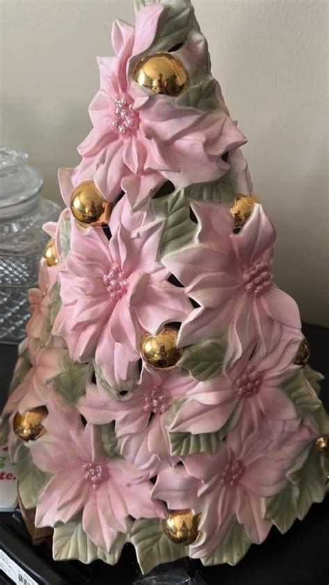 A Pink And Green Christmas Tree Made Out Of Ceramic Flowers On A Black