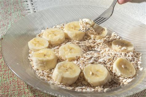 flocos de aveia e banana fatiada em um prato que está em uma mesa