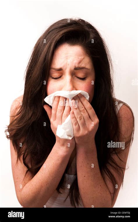 A Young Woman With Brown Hair And Eyes Feeling Ill Sneezing Blowing Her