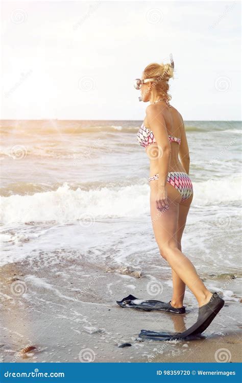 Mujer En Bikini Con Las Aletas Y Las Gafas En La Playa Foto De Archivo