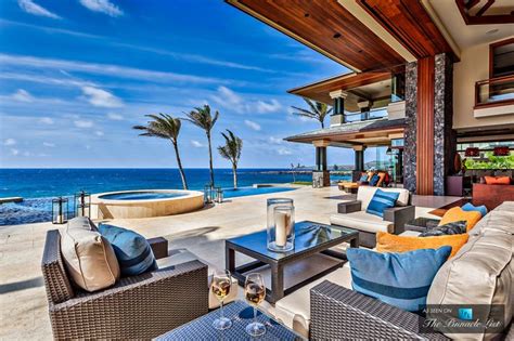 An Outdoor Living Area With Couches And Tables Overlooking The Ocean